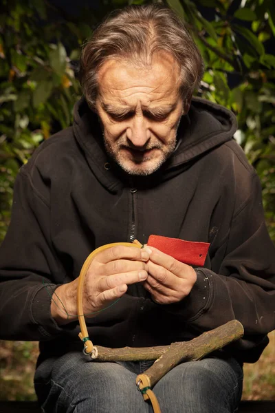 老年人用木叉完成传统弹弓 — 图库照片