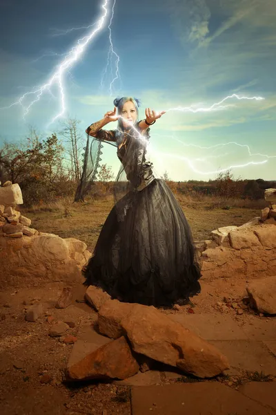 謎の女魔術師は稲妻の力で廃墟と戦う準備ができている — ストック写真