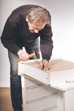 Üç katmanlı ahşap çekmeceleri birleştiren adam.