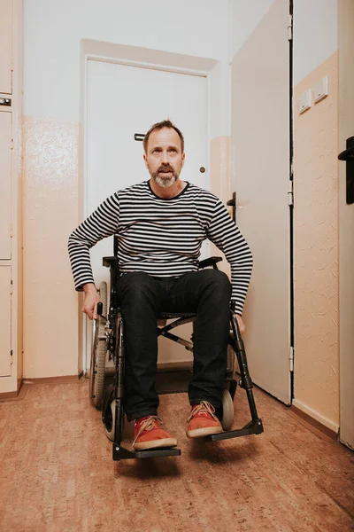 坐在轮椅上的残疾人离开了他在前屋的公寓 — 图库照片