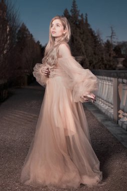 Gece kalesi bahçesinde poz veren güzel bir bayan.