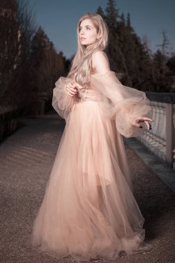 Gece kalesi bahçesinde poz veren güzel bir bayan.