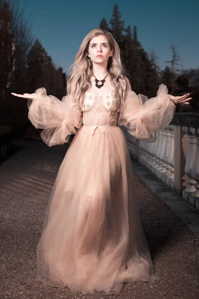 Gece kalesi bahçesinde poz veren güzel bir bayan.