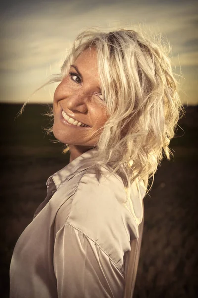 Pretty lady in summer apparel posing on harvested cornfield