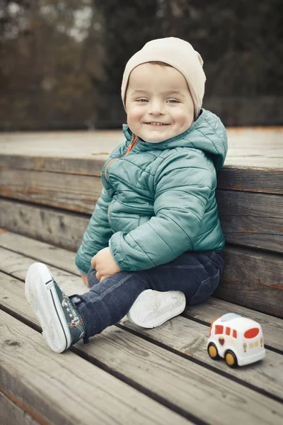Mały Chłopiec Jesiennym Parku Pozuje Portretu Drewnianej Ławce — Zdjęcie stockowe