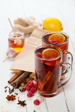 Cup of Hot winter raspberry tea with cinnamon sticks