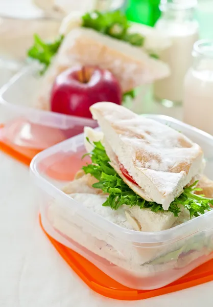 Lunch box with sandwich apple and milk