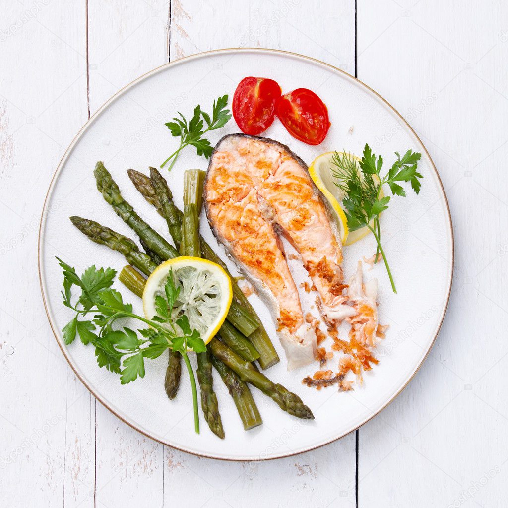 Grilled salmon with asparagus on white plate — Stock Photo © lisovskaya