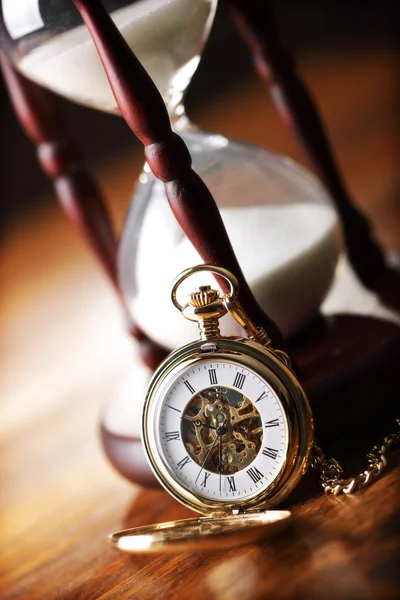 Gold pocket watch and hourglass — Stock Photo, Image