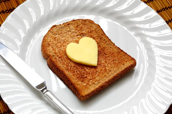 Heart shaped butter on toast — Stock Photo, Image