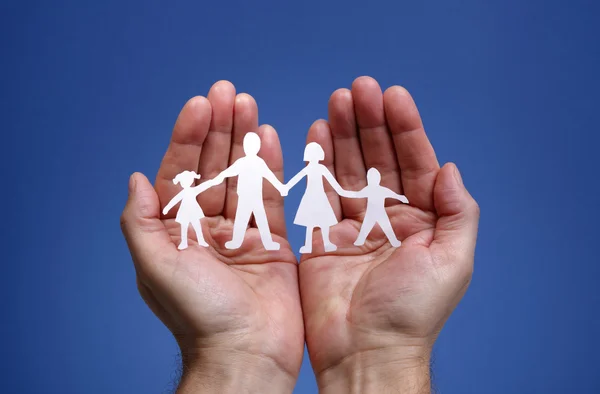 Paper chain family protected in cupped hands — Stock Photo, Image