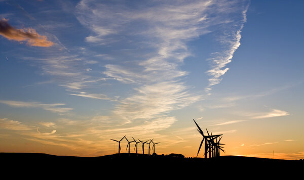 Wind turbines against sunset