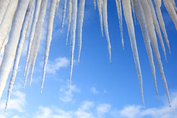 Mavi bir gökyüzü karşı asılı buz sarkıtları — Stok fotoğraf