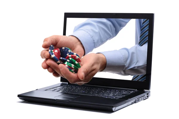 Online-Glücksspiel Konzept Mann hält Pokerchips durch einen Laptop-Bildschirm — Stockbild Internet-Glücksspiel — Stockfoto