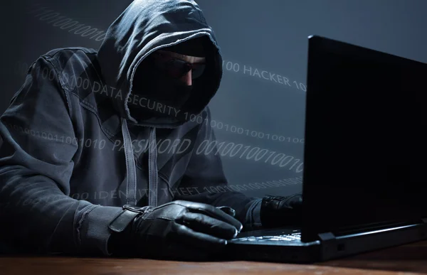 Hacker stealing data from a laptop — Stock Photo, Image