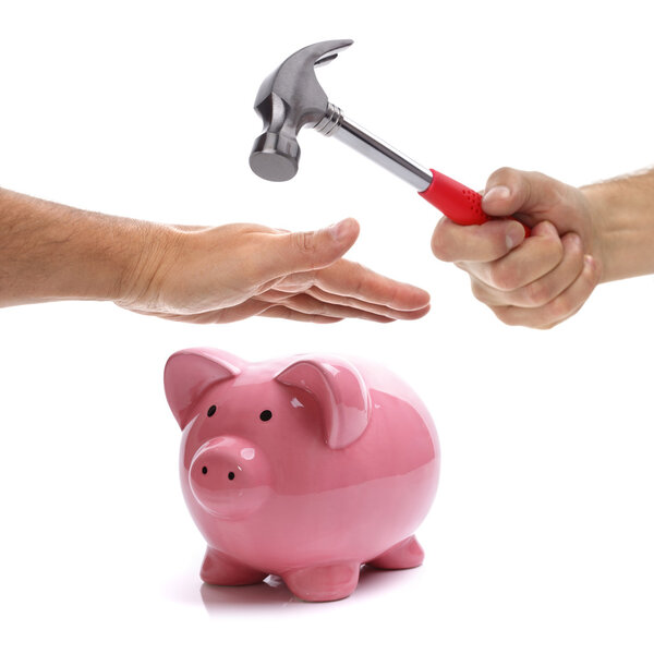 Hand with hammer about to smash piggy bank