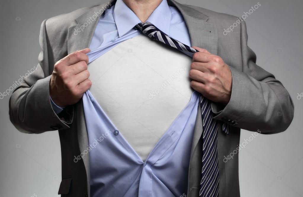 Businessman in classic superman pose tearing his shirt open to reveal t shirt with blank chest for message