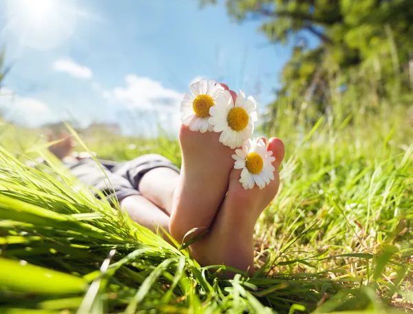 Criança deitada no prado relaxando no sol de verão — Fotografia de Stock