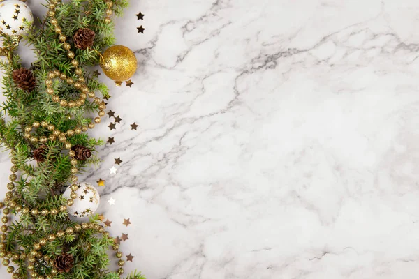 Різдвяна листівка або рамка з гілками ялинки та святковим декором на світло-сірому мармуровому фоні з сосновим конусом — стокове фото