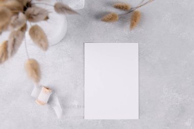 blank card mockup, wedding stationery invitation on grey stone table background with white ribbon, feminine blog flat lay, top view. Minimalist mockup, ratio 3,5x5, Simple bohemian style mockup