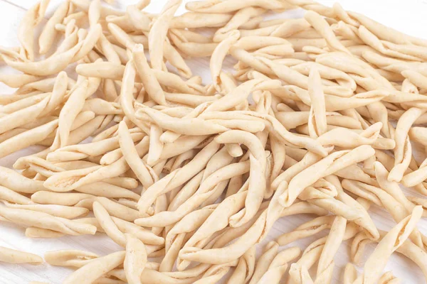 Whole grain wheat raw apulian pasta called Pizzarieddi or maccaruni on a on white wooden table — Foto de Stock