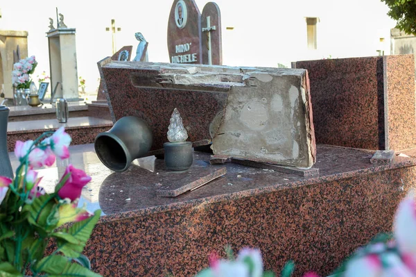 A broken gravestone made of granite, a desecrated grave, a profanation of a cemetery, Italy — Stock Photo, Image