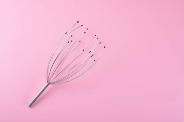 Baş ve boyun masaj aleti pembe arka planda izole edilmiş. Ev yapımı akupunktur noktası kafa derisi ahtapot masaj aleti. Baş ağrısı, ağrı ve stres giderici, rahatlama için kılcal masaj aleti