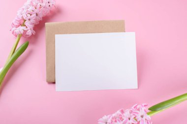 Blank wedding invitation stationery card mockup with envelope on pink background with hyacinth flowers