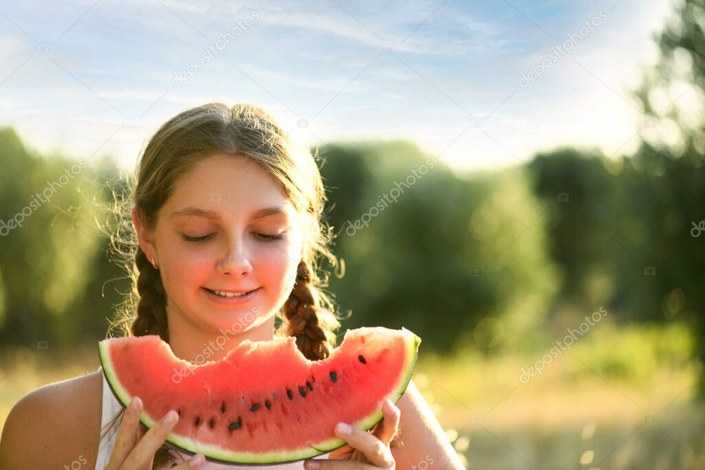 Portrait of young happy smiling girl with half red fresh watermelon enjoying summer life outdoors. Summer lifestyle concept. Happiness, joy, holiday Independence Day, copy space