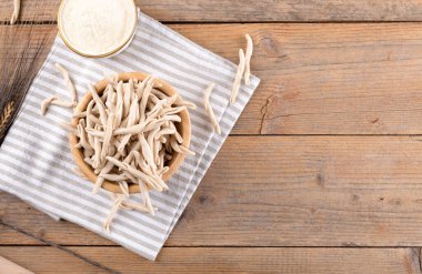 Tahta masadaki bir kasede tam tahıllı apulian makarnası Pizzarieddi veya maccaruni. Taze Maccheroni tipik Puglia yemeği, Salento İtalya. İtalyan ev yapımı makarna arka plan, üst manzara, düz yatak