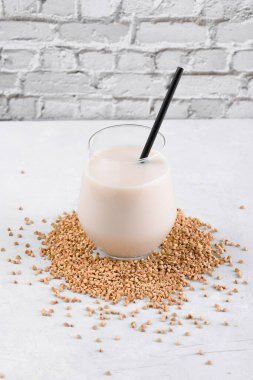 Vejetaryen günlük olmayan karabuğday sütü ve beyaz taş bir masada karabuğday filizleri. Vegan karabuğday içeceği, bitki bazlı alternatif süttür. Sebzeler sağlıklı süt ürünü, yakın çekim, seçici odaklanma