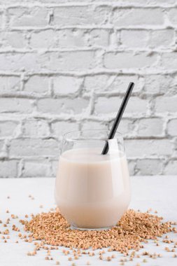 Vejetaryen günlük olmayan karabuğday sütü ve beyaz taş bir masada karabuğday filizleri. Vegan karabuğday içeceği, bitki bazlı alternatif süttür. Sebzeler sağlıklı süt ürünü, yakın çekim, seçici odaklanma