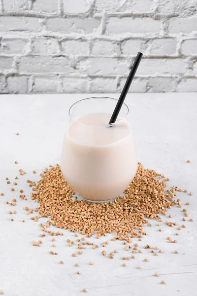 Vejetaryen günlük olmayan karabuğday sütü ve beyaz taş bir masada karabuğday filizleri. Vegan karabuğday içeceği, bitki bazlı alternatif süttür. Sebzeler sağlıklı süt ürünü, yakın çekim, seçici odaklanma