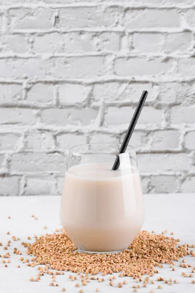 Vejetaryen günlük olmayan karabuğday sütü ve beyaz taş bir masada karabuğday filizleri. Vegan karabuğday içeceği, bitki bazlı alternatif süttür. Sebzeler sağlıklı süt ürünü, yakın çekim, seçici odaklanma