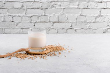 Vejetaryen günlük olmayan karabuğday sütü ve beyaz bir masada karabuğday filizleri. Sebzeler sağlıklı süt ürünü, kopyalama alanı