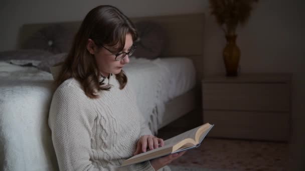 Giovane Donna Occhiali Vista Indossa Maglione Sta Leggendo Libro Accogliente — Video Stock