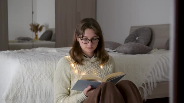 Mujer Joven Gafas Graduadas Vistiendo Suéter Está Leyendo Libro Acogedora — Vídeo de stock