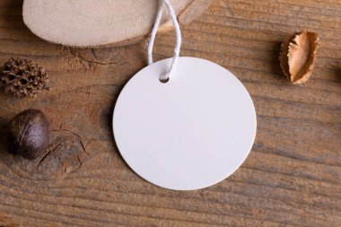 Pamuk iplik ve boho dekorasyonlu, kırsal ahşap arka planda yuvarlak beyaz etiket modeli, paketleme elementi, kapat. Metin ve doğal eko tasarımı için ürün bohem kopyalama alanı etiketlensin.