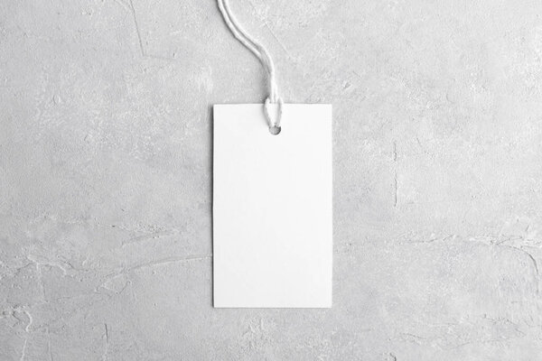 Rectangle white tag mockup with white cord, close up. Blank paper rectangular price tag mockup isolated on grey background with copy space, Sale and Black Friday concept