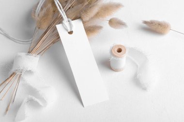 Pamuk iplik, boho dekorasyonu, kuru bitkiler ve paketleme elementi ile beyaz arka planda dikdörtgen beyaz etiket modeli. Metin ve doğal eko tasarımı için ürün bohem kopyalama alanı etiketlensin