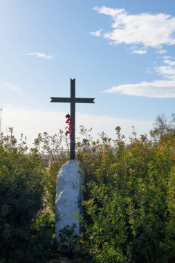 Hz. İsa, mavi bir arka planda bitkiler, bulutlar ve güneş ışınlarıyla kesişiyor. Paskalya, diriliş konsepti. Tanrı 'nın Hristiyan haçı dışarıda güneş ışınlarında tarlada. Din arkaplanı
