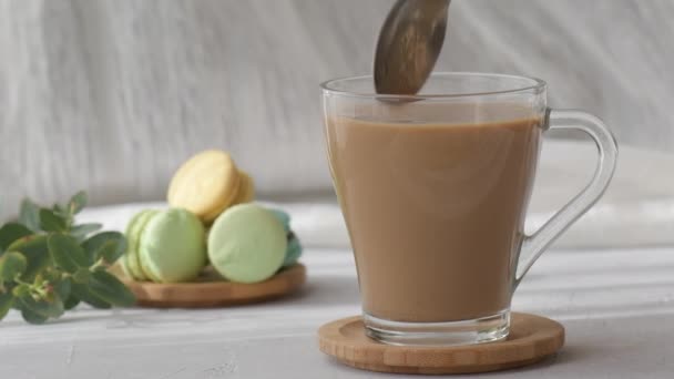 糖从勺子中倒入透明的咖啡中 动作缓慢 勺子在咖啡杯里加了糖 是在搅拌杯子里的糖 — 图库视频影像