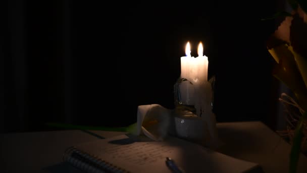 Дві Свічки Горять Столі Біля Паперу Віршами Ручкою Квіткою Хтось — стокове відео