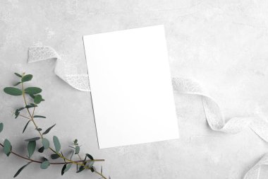 Wedding stationery invitation cards mockup 5x7 on neutral grey stone background with eucalyptus leaves clipart