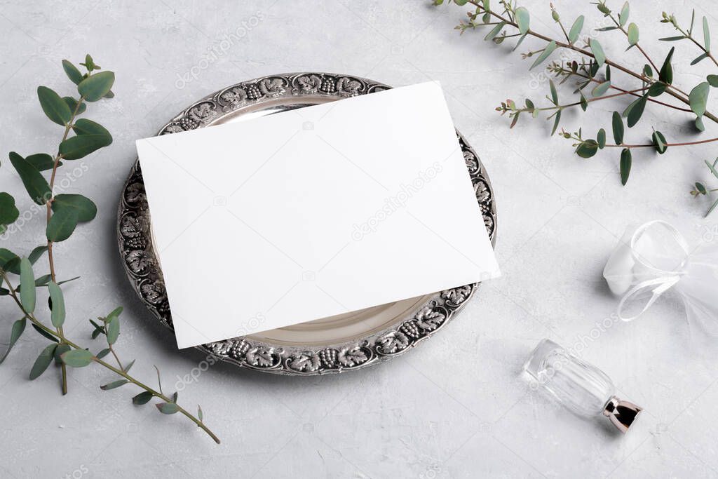 Wedding stationery invitation card mockup 7x5 on silver retro vintage plate on grey background with eucalyptus, Menu card mockup with festive wedding or birthday table setting with blank card mockup
