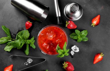 Soğuk yaz çilekli mojito, margarita, martini bardağında daiquiri. Buzlu taze çilekli içecek, barmen aletleri seti ve arka planda nane yaprakları. Buzlu çilekli limonata, yukarıda.