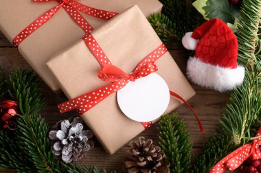 Noel Baba şapkası, ürün etiketi maketi, doğal köknar ağacı dalı, koni ve Noel süslemesi, Noel satışı konsepti...