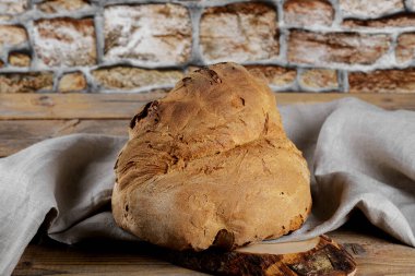 The bread of Matera, Pane di Matera on wooden background, typical southen italian sourdough bread, the crunchy loaf has the shape of a croissant and is produced with the use of durum wheat semolina