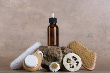 Amber glass dropper bottle mockup for serum on stone podium on beige terracotta background with set for bathroom accessories, skin and body care, Natural cosmetic packaging mockup, skincare routine