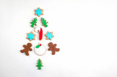 Beyaz arka planda Noel ağacı şeklinde çeşitli Noel kurabiyeleri. Alternatif Yenilebilir Noel Ağacı, Üst Manzara, düz yatış. Noel kurabiyeleri arka planda